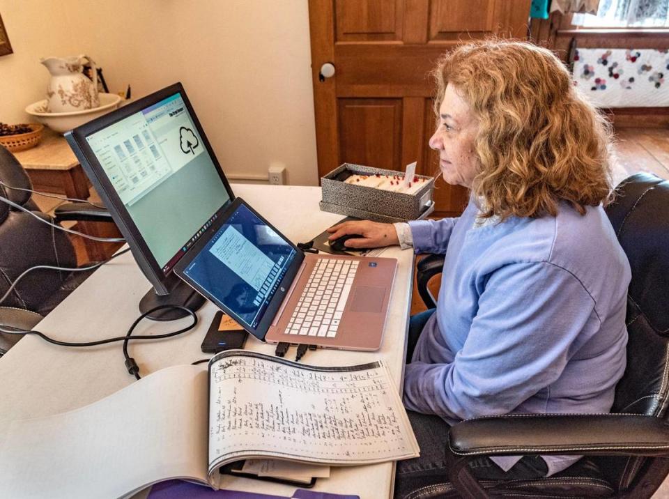 Jody Mantarro, a volunteer with the Union Cemetery Historical Society, works inside the sexton’s cottage, adding obituaries, photos and other biographical information to the names of some of the 55,000 people buried there.