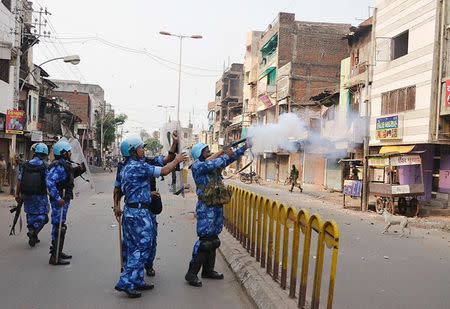 A Rapid Action Force (RAF) member fires a tear gas shell to disperse a mob after clashes in Vadodara in the western Indian state of Gujarat September 26, 2014. REUTERS/Stringer