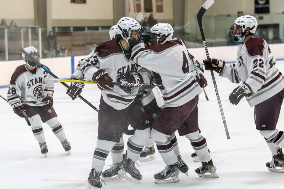 Bishop Stang's Justin Gouveia (23) is mobbed by his teammates after scoring his third goal of the the game late in the third period.