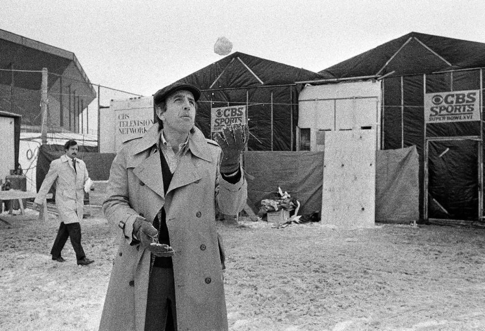 FILE - In this Jan. 20, 1982, file photo, CBS Sportscaster Brent Musburger plays with a snowball outside the Silverdome in Pontiac, Mich., where the XVI Super Bowl will be played. Musburger is calling an end to his broadcast career. Millions of Americans experienced sporting events through his folksy narration, most often when he was the lead voice of CBS Sports during the 1980s. Musburger will call his last game for ESPN on Jan. 31, a college basketball contest pitting Kentucky against Georgia. (AP Photo/File)