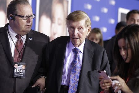 Sumner Redstone (C), executive chairman of CBS Corp. and Viacom, is assisted as he arrives at the premiere of "The Guilt Trip" starring Barbra Streisand and Seth Rogen in Los Angeles in this December 11, 2012, file photo. REUTERS/Fred Prouser/Files