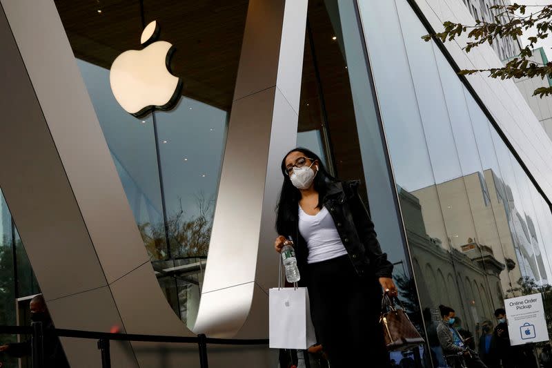 FILE PHOTO: A customer exits after picking up Apple's new 5G iPhone 12 that went on sale at an Apple Store in Brooklyn, New York