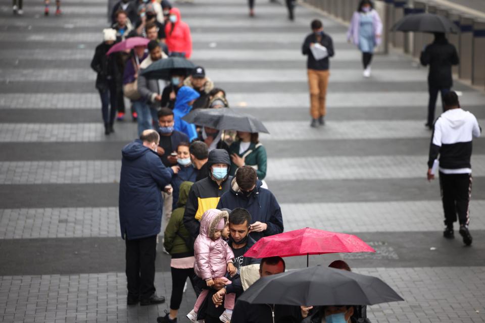 People queue outside a mass vaccination centre at Tottenham Hotspur Stadium (REUTERS)