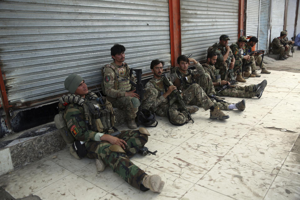 Afghan security personnels rest in front of a prison after an attack in the city of Jalalabad, east of Kabul, Afghanistan, Monday, Aug. 3, 2020. An Islamic State group attack on the prison in eastern Afghanistan holding hundreds of its members raged on Monday after killing people in fighting overnight, a local official said. (AP Photo/Rahmat Gul)