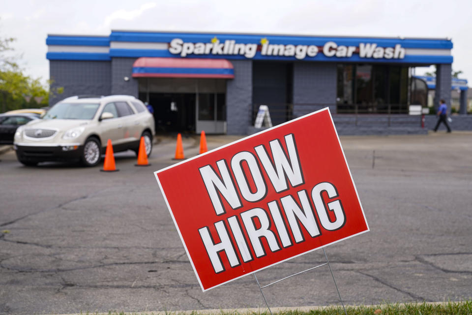 FILE - In this Sept. 2, 2020, file photo, a help wanted sign is displayed at car wash in Indianapolis. The number of Americans seeking unemployment benefits fell last week of Oct. 19, to 751,000, the lowest since March but a figure that remains historically high and indicates the viral pandemic is still forcing many employers to cut jobs. (AP Photo/Michael Conroy, File)