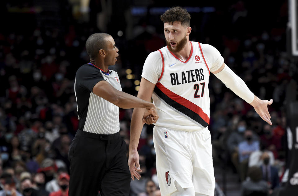 Portland Trail Blazers center Jusuf Nurkic, right, speaks with referee Phenizee Ransom during the first half of the team's NBA basketball game against the Sacramento Kings in Portland, Ore., Wednesday, Oct. 20, 2021. (AP Photo/Steve Dykes)