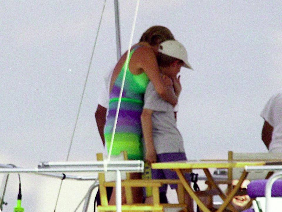 Princess Diana hugs Prince Harry on a boat.