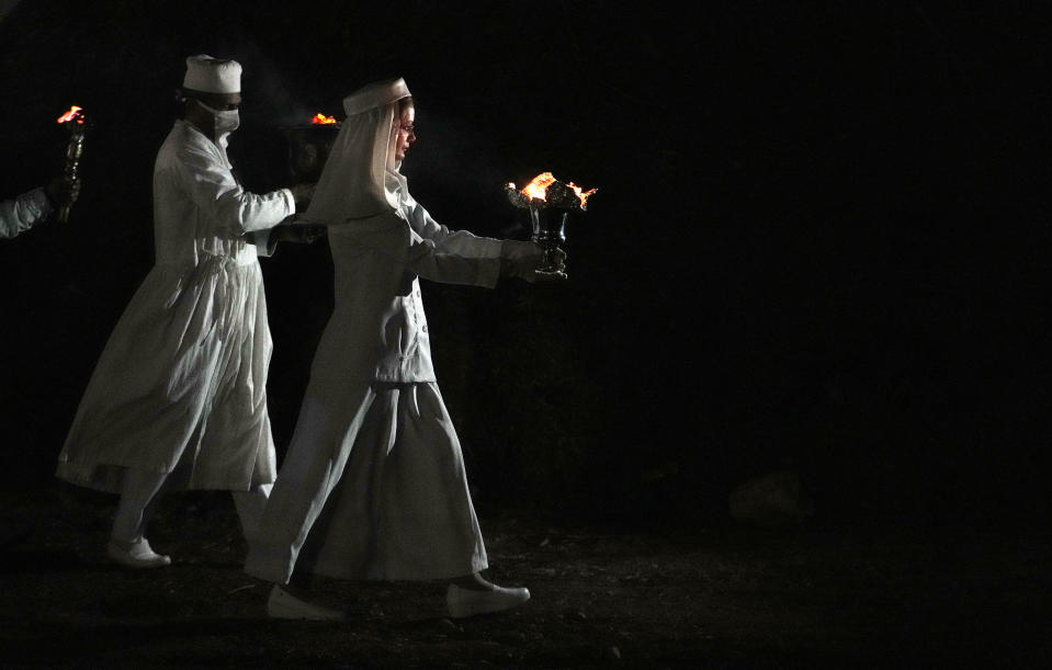 Iranian Zoroastrian priests prepare to set fire to a pile of wood in a ceremony celebrating Zoroastrians ancient mid-winter Sadeh festival in the outskirts of Tehran, Iran, Tuesday, Jan. 30, 2024. Hundreds of Zoroastrian minorities gathered after sunset to mark their ancient feast, creation of fire, dating back to Iran's pre-Islamic past. (AP Photo/Vahid Salemi)