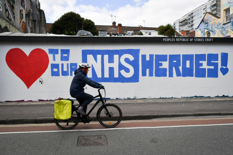 A cyclist passes street art in Stokes Croft, Bristol, as the UK enters the second week of lockdown due to the global coronavirus pandemic.