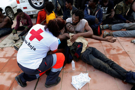 A Spanish Red Cross worker aids African migrants after they crossed a border fence between Morocco and Spain's north African enclave of Ceuta October 31, 2016. REUTERS/M. Martin