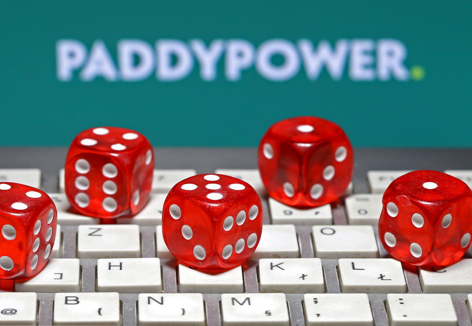 Flutter Entertainment: Paddy Power logo is seen behind a keyboard and gambling dice. 