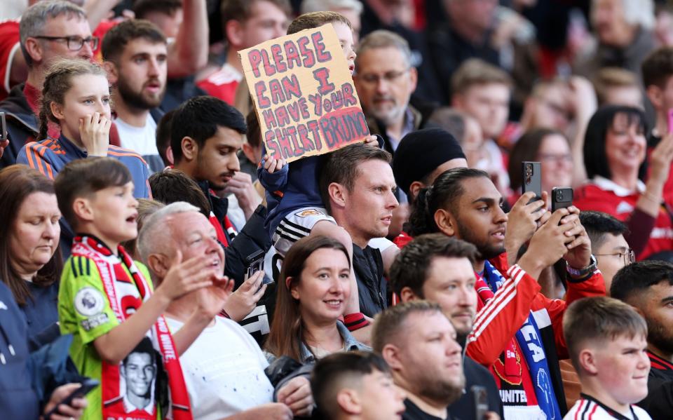 A fan of Manchester United holds a sign asking for the shirt of Bruno Fernandes of Manchester United prior to the Premier League match between Manchester United and Chelsea FC at Old Trafford - Catherine Ivill/Getty Images