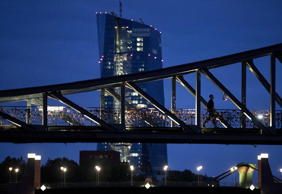 A man walks over a bridge with the European Central Bank in background in Frankfurt, Germany, Tuesday, Sept. 17, 2019. (AP Photo/Michael Probst)