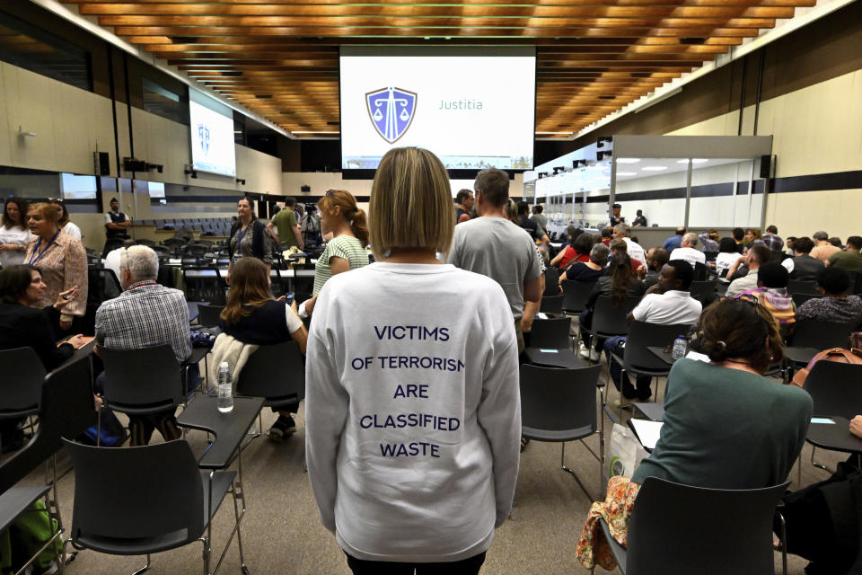 A member of the United Organisation of Victims stands in the courtroom prior to the reading of the sentences during the trial regarding the attacks at a Brussels metro station and the city's airport at the Justitia building in Brussels, Friday, Sept. 15, 2023. The morning rush hour attacks at Belgium's main airport and on the central commuter line took place on March 22, 2016, which killed 32 people, and nearly 900 others were wounded or suffered mental trauma. (John Thys, Pool Photo via AP)