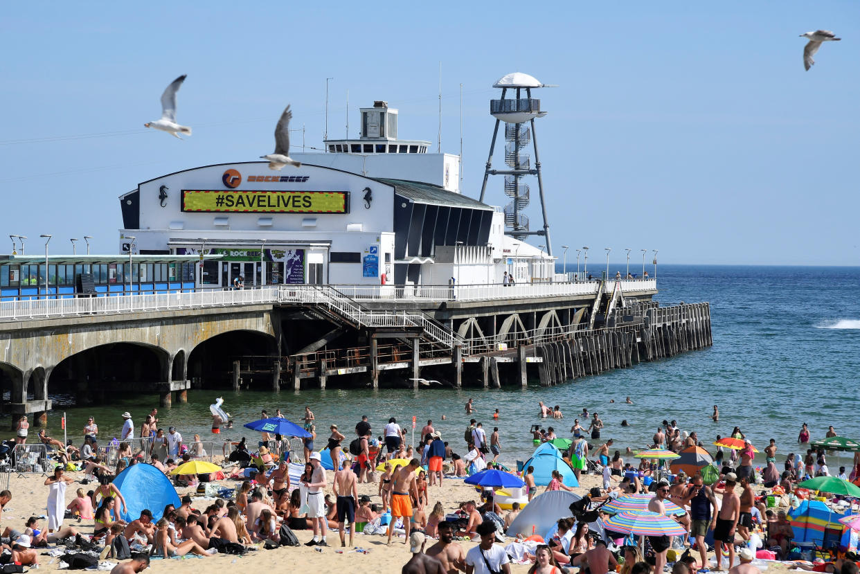 A message reading 'Save Lives' is seen on Bournemouth Pier as people enjoy the hot weather on the beach, following the outbreak of the coronavirus disease (COVID-19), Bournemouth, Britain, June 2, 2020. REUTERS/Toby Melville