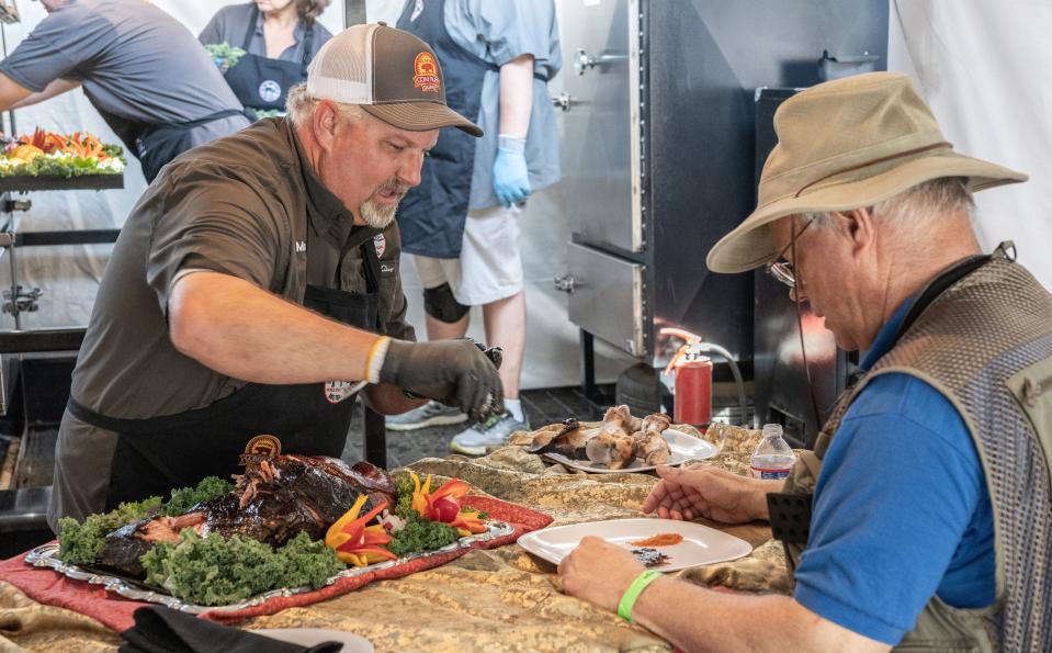 A Memphis in May World Championship Barbecue Cooking Contest judge listens intently while a competitor does his on-site presentation.