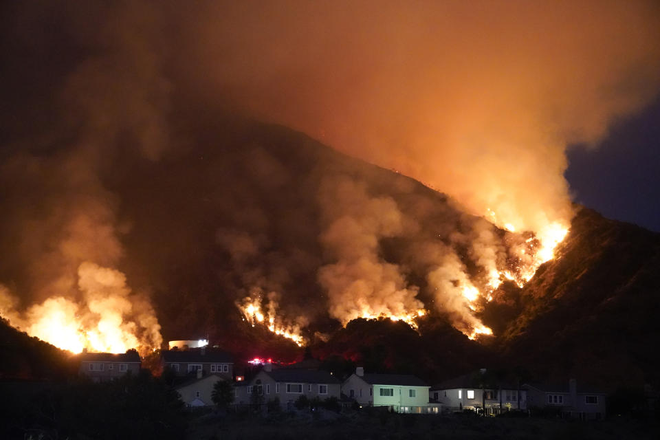 The Ranch Fire burns over a residential area, Thursday, Aug. 13, 2020, in Azusa, Calif. Heat wave conditions were making difficult work for fire crews battling brush fires and wildfires across Southern California. (AP Photo/Marcio Jose Sanchez)