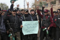 Police officers chant slogans as they take part in a peace march organized by a civil society group denouncing militant attacks and demanding peace in the country, in Peshawar, Pakistan, Wednesday, Feb. 1, 2023. The placard is center in Urdu language reading as"Why is the blood of KP police so cheap?". (AP Photo/Muhammad Sajjad)