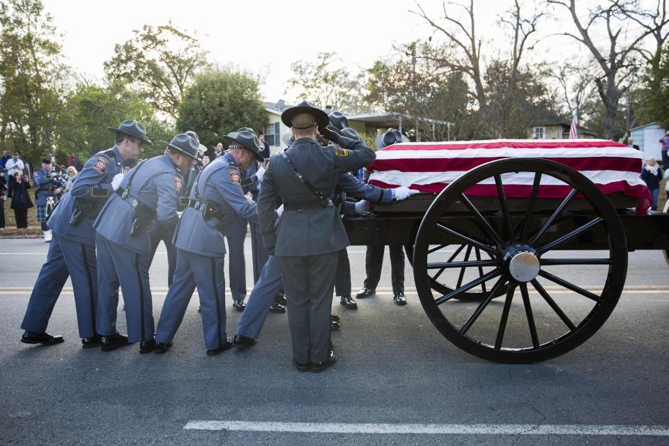 An honor guard loads the casket of Americus police officer Nicholas Smarr on to a caisson following a funeral service at the Georgia Southwestern State University Storm Dome, Sunday, Dec. 11, 2016, in Americus, Ga. Smarr and Jody Smith, an officer with Georgia Southwestern State University, were shot and killed while responding to a domestic violence call. (AP Photo/Branden Camp)