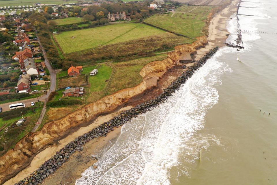 The end of a tarmac road shows the devastation caused by coastal erosion of the cliff face in the village of Happisburgh on November 06, 2019 in Great Yarmouth, England. The sea defences, which were built in the late 1950s at Happisburgh, north Norfolk have been failing over recent years with erosion of the sandy cliffs causing many buildings and farmland to be lost to the sea. The effects of global climate change causing storms and sea swells has seen the East Coast of the United Kingdom lose up to one metre of coast line each year.