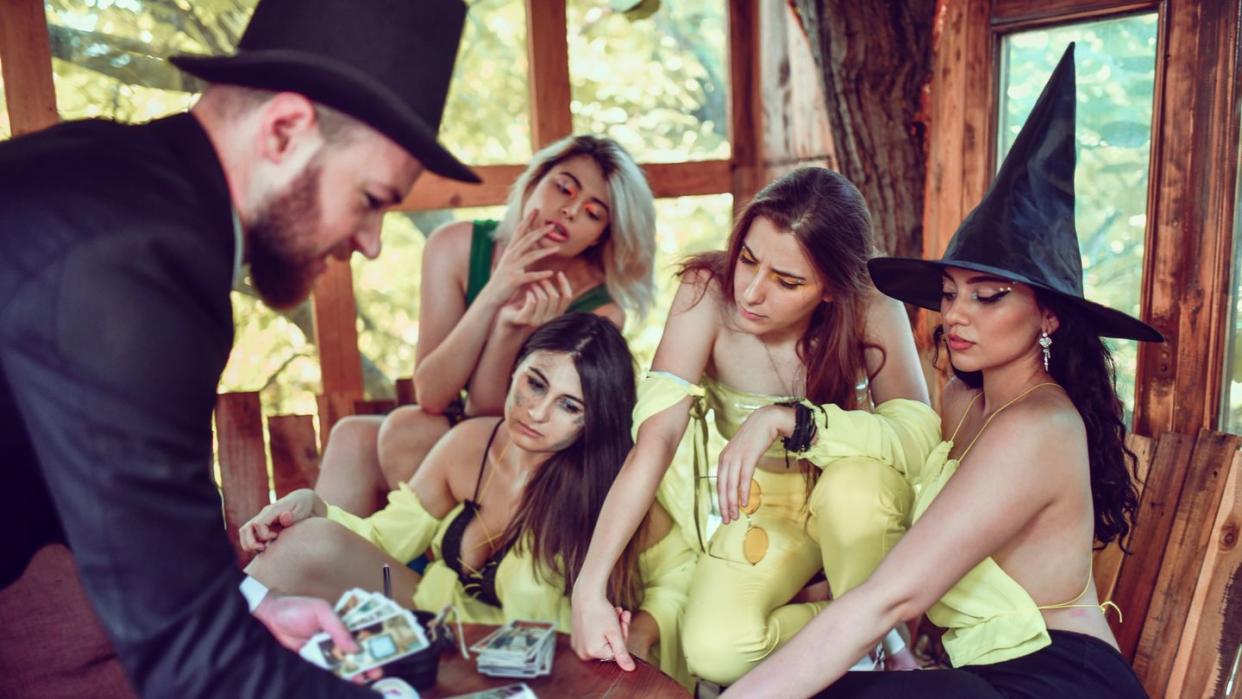 male magician making females believe in his tarot reading skills
