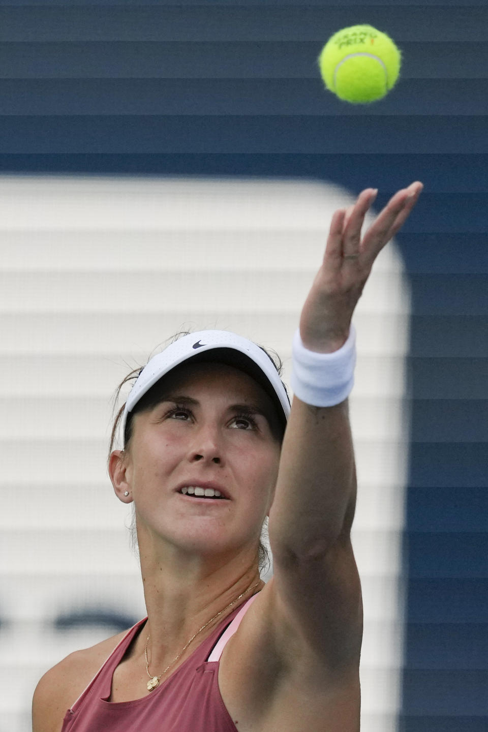 Belinda Bencic of Switzerland tosses the ball up to serve in her women's semifinal match against Naomi Osaka of Japan, at the Miami Open tennis tournament, Thursday, March 31, 2022, in Miami Gardens, Fla. (AP Photo/Rebecca Blackwell)