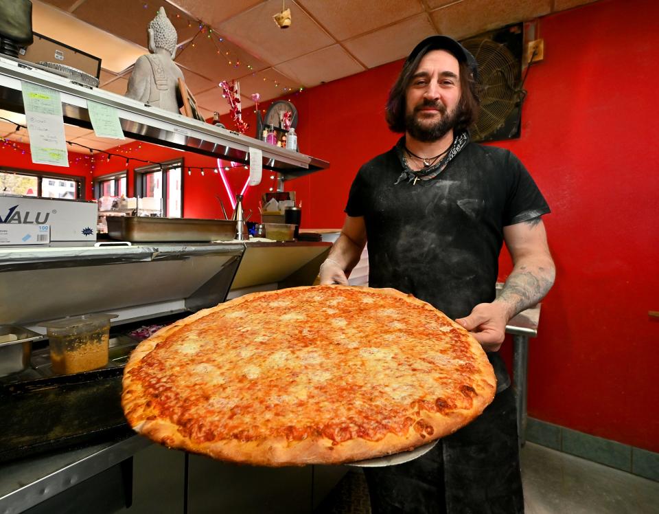 I Love Frankie’s owner and pizza chef Frank Abbatecola holds a 24-inch El Presidente cheese pizza.