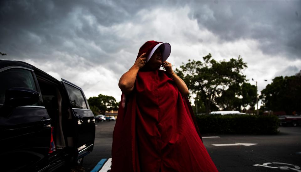 Pro-choice protester, Amanda Peterson of the SWFL Red Cloaks prepares for a protest downtown Fort Myers on Tuesday. Supporters and opponents of abortion rights were present. Members for abortion rights held the protest in response to a leaked draft opinion from the Supreme Court seeking to overturn Roe v. Wade.