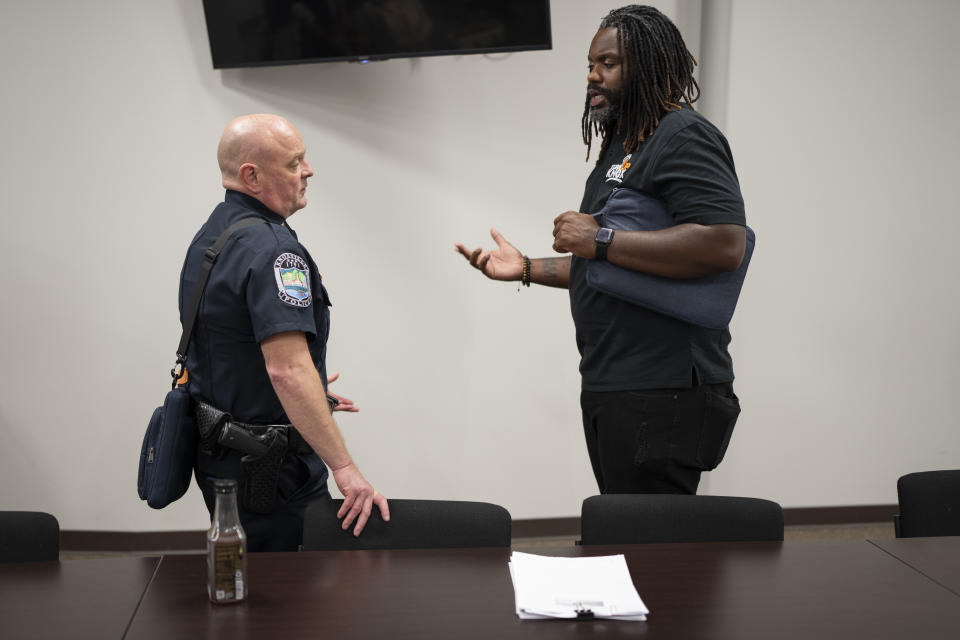 Knoxville Deputy Police Chief Tony Willis, left, talks with Turn Up Knox executive director Denzel Grant after a meeting of the Violence Reduction Leadership Committee on Thursday, Aug. 3, 2023 in Knoxville, Tenn. The city saw a spike in gun deaths in 2020 and 2021, with a gun homicide rate that at one point in 2021 rivaled Chicago's. (AP Photo/George Walker IV)