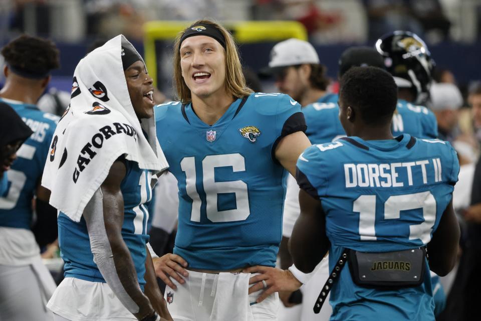 Jacksonville Jaguars' Laviska Shenault Jr., left, Trevor Lawrence (16) and Phillip Dorsett II (13) talk on the sideline in the first half of a preseason NFL football game against the Dallas Cowboys in Arlington, Texas, Sunday, Aug. 29, 2021. (AP Photo/Michael Ainsworth)