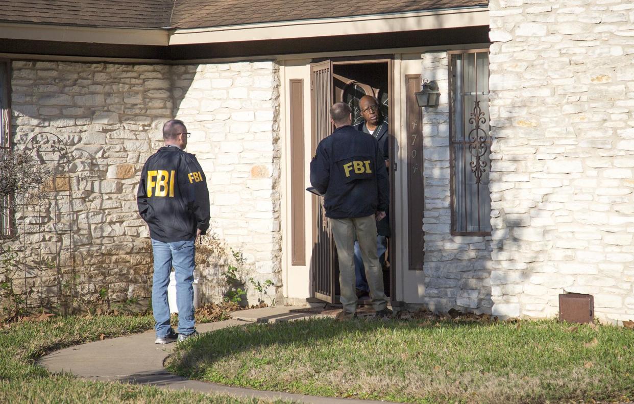 The FBI is pictured investigating the scene in East Austin, Texas, after a teenager was killed by a package explosion: AP