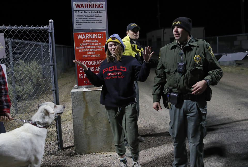 Sheriff's deputies escort a woman who ducked under the gate at an entrance to the Nevada Test and Training Range near Area 51, Sept. 20, 2019, near Rachel, Nev. People gathered at the gate inspired by the "Storm Area 51" internet hoax.  (Photo: John Locher/AP)