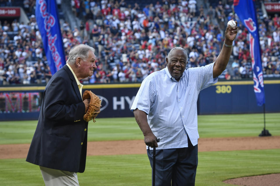 Hank Aaron holds up the ball after throwing the ceremonial last pitch to former Manager Bobby Cox after a baseball game against the Detroit Tigers and the Braves last game at Turner Field, Oct. 2, 2016, in Atlanta. (AP Photo/John Amis)