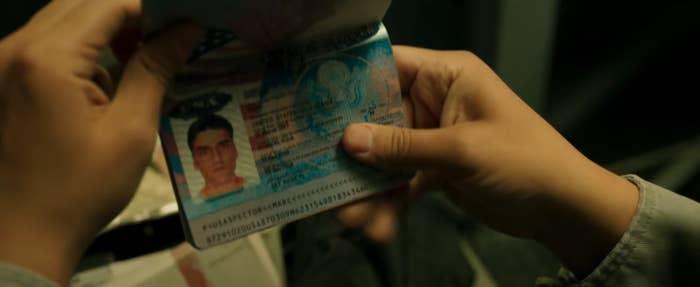 Two hands holding a passport for "Marc Spector"