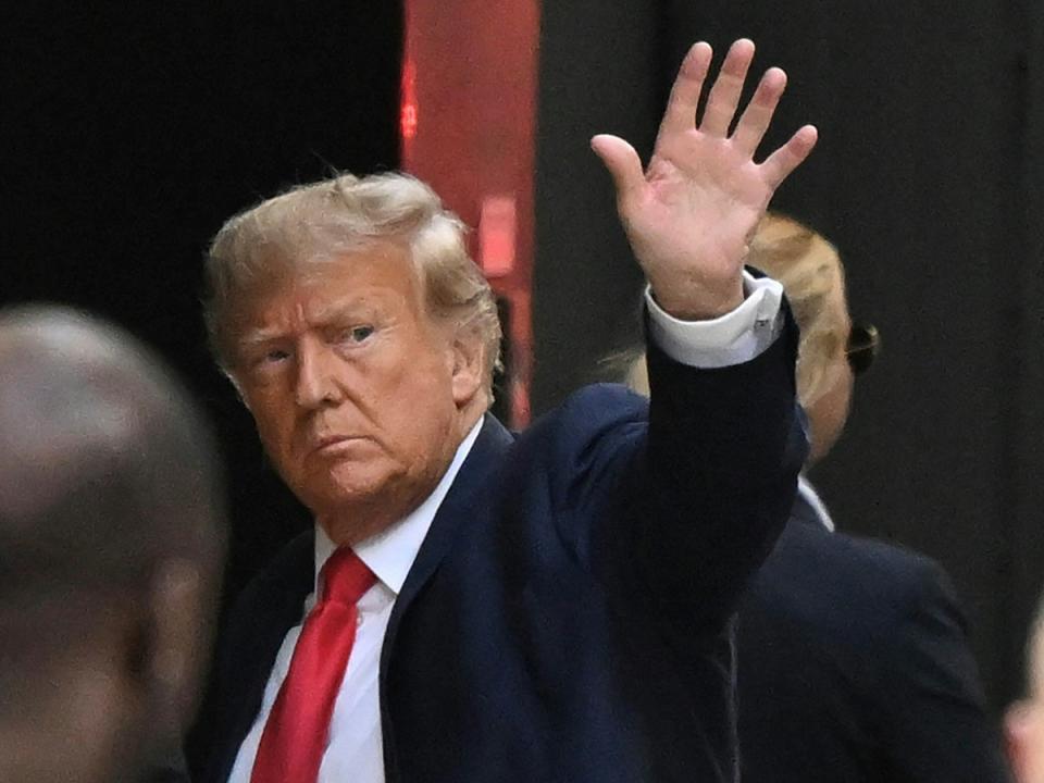 Former US President Donald Trump waves as he arrives at Trump Tower in New York on April 3, 2023 (AFP via Getty Images)
