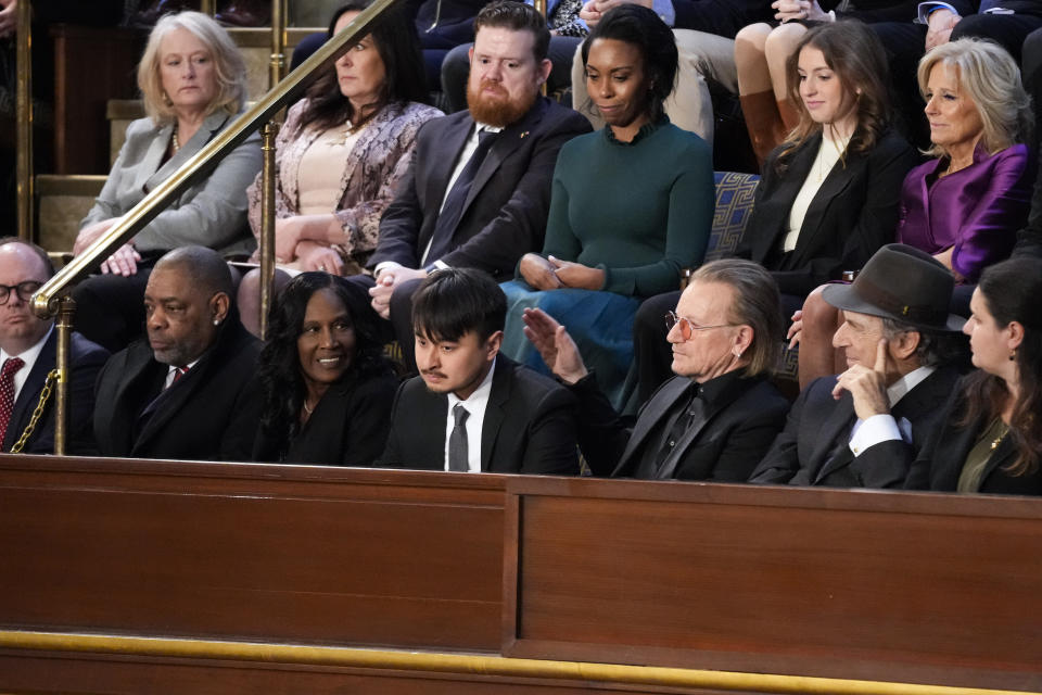 Bono, the Irish lead singer of U2, third from right, pats Brandon Tsay on the back as he is recognized by President Joe Biden as Biden delivers the State of the Union address to a joint session of Congress, at the Capitol in Washington, Tuesday, Feb. 7, 2023. Tsay disarmed the accused gunman in a mass shooting last month in California. (AP Photo/Patrick Semansky)