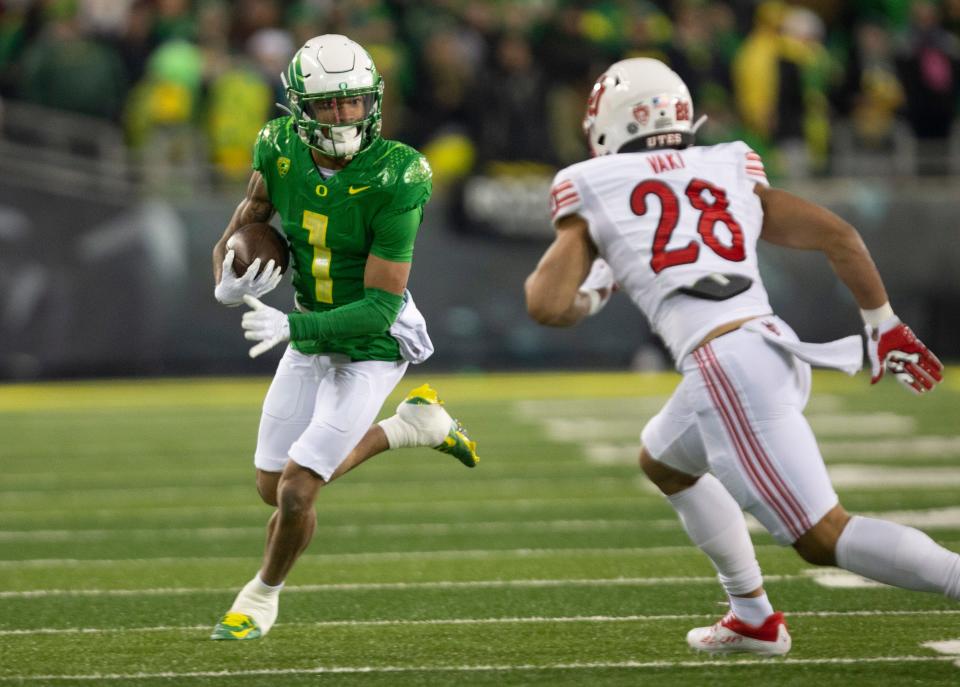 Oregon's Kris Hutson, left, rushes against Utah's Sione Vaki during the first quarter at Autzen Stadium on Nov. 19, 2022.