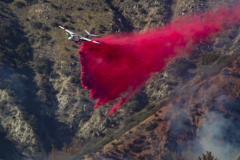 Lytle Creek, CA - December 26: An air tanker drops fire retardant on a slow moving 45 acres brush fire above Glen Helen Parkway on Saturday, Dec. 26, 2020 in Lytle Creek, CA. (Irfan Khan / Los Angeles Times)