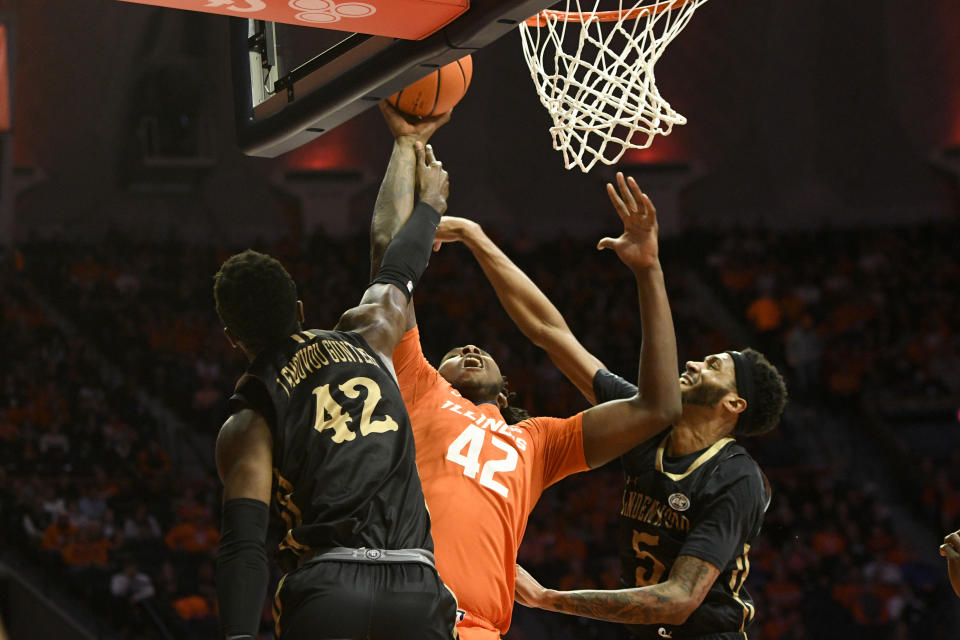 Illinois' Dain Dainja (42) lays the ball up as Lindenwood's Remy Lemovou (42) and Cam Burrell (5) defend during the first half of an NCAA college basketball game, Friday, Nov. 25, 2022, in Champaign, Ill. (AP Photo/Michael Allio)