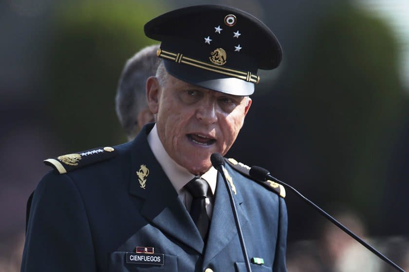 Gen. Salvador Cienfuegos speaks into a microphone in dress uniform.