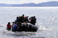 Migrants board a dinghy to reach the Greek island, in Ayvacik, Canakkale, Turkey, Friday, Feb. 28, 2020. NATO envoys were holding emergency talks Friday at the request of Turkey following the killing of 33 Turkish soldiers in northeast Syria, as scores of migrants gathered at Turkey's border with Greece seeking entry into Europe.(DHA via AP)