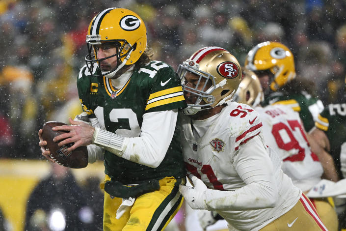 GREEN BAY, WISCONSIN - El quarterback Aaron Rodgers #12 de los Green Bay Packers es atrapado por el ala defensivo Arik Armstead #91de los San Francisco 49ers den el segundo cuarto del partido del playoff divisional de la NFL ante los San Francisco 49ers en Lambeau Field el 22 de enero de 2022 en Green Bay, Wisconsin. (Foto por Quinn Harris/Getty Images)