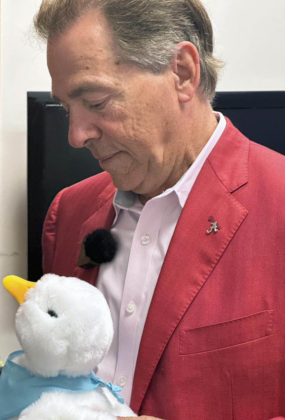 Alabama NCAA college football head coach Nick Saban examines one of the robotic ducks from Aflac that he handed out to kids at Children's Hospital in Birmingham, Alabama on Tuesday, June 6, 2023. (AP Photo/John Zenor)