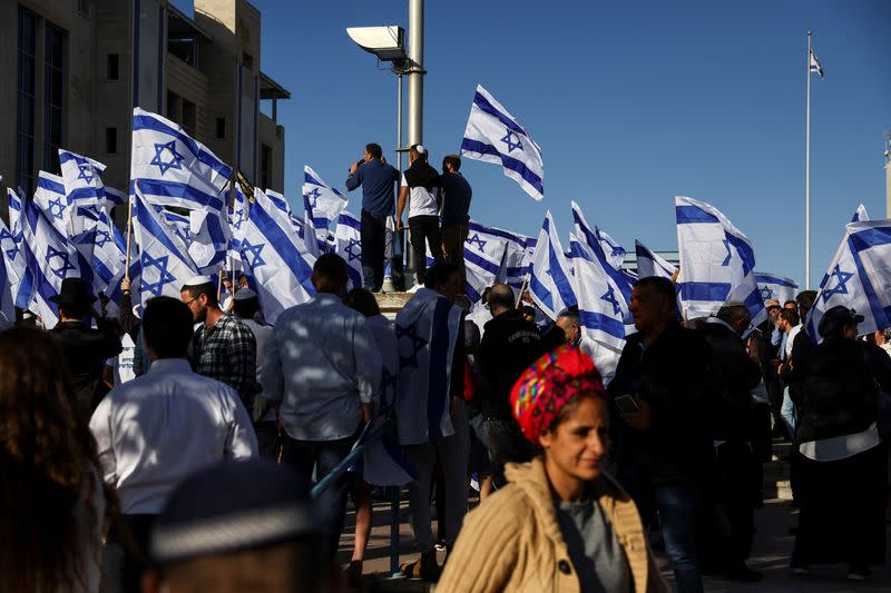 Israeli right wing protestors shout slogans as they hold national flags during a rally in Jerusalem