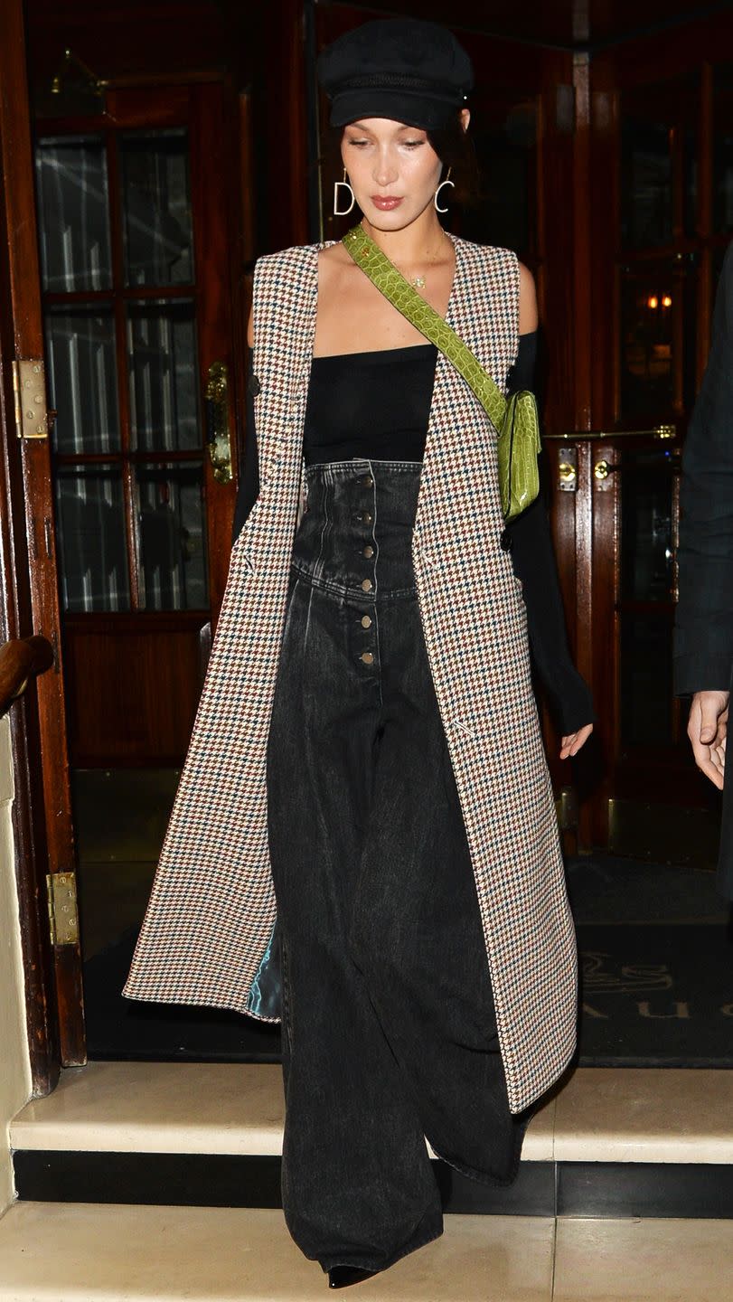 <p>In a houndstooth long vest, ultra high-waisted wide-leg jeans, off-the-shoulder top, alligator leather crossbody by Stalvey, Liudmila boots, newsboy cap, and Christian Dior earrings while out in London.</p>