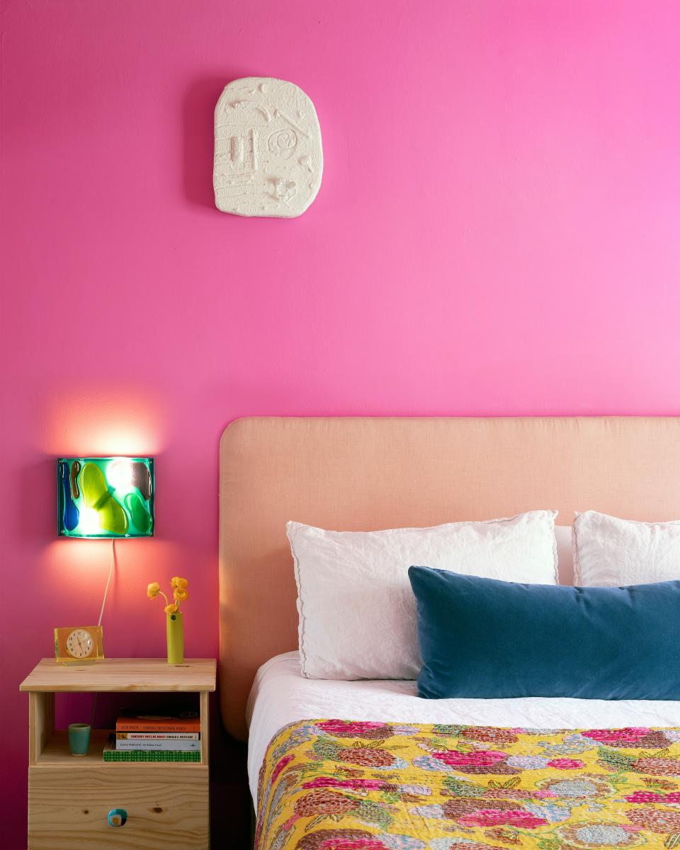 “I love waking up to this color every day,” says Leah of her and Adam’s bedroom, painted Benjamin Moore’s Spring Azalea (he was totally down). Another Human sconces and an artwork by Don Edler adorn the wall. The bed is covered in a contemporary kantha quilt and the IKEA bedside table sports a fused-glass pull from Etsy.