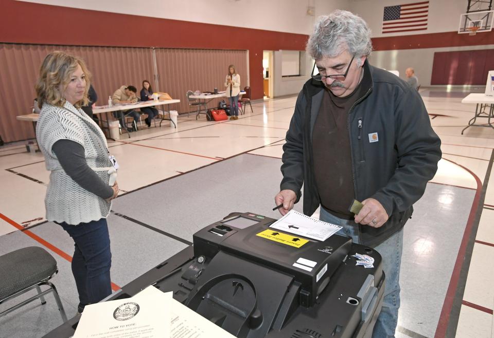 During the 2022 midterm elections, machine operator Jeanine Timon, 53, at left, watches, Leonard Stahlman, 68, scans his ballot, on Nov. 8, 2022, at the Fairview Township, Erie County 4th district polling place at Weis Library United Methodist Church at the eastern edge of the township. 
