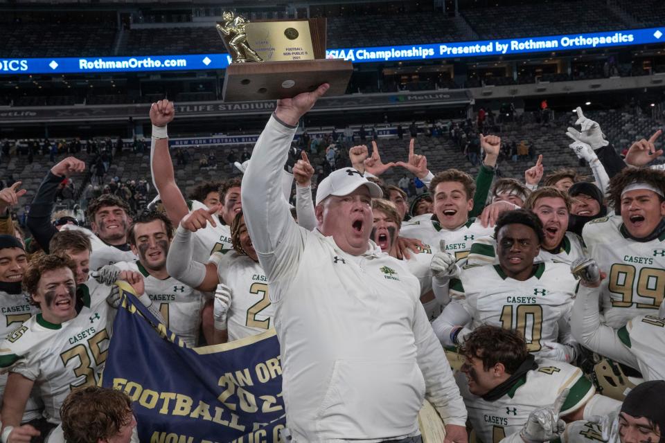 Red Bank Catholic head coach Mike Lange holds the NJSIAA Nonpublic B championship trophy after the Caseys defeated DePaul 13-8 Friday night at MetLife Stadium.