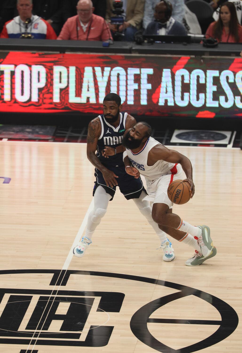 Clippers shooting guard James Harden dribbles under pressure from the Dallas Mavericks' Tim Hardaway Jr.