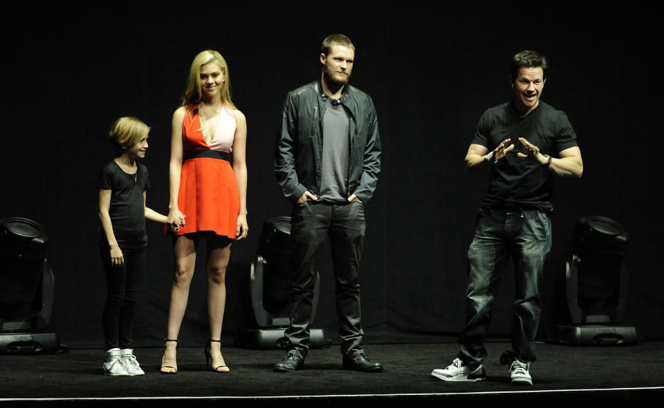 Mark Wahlberg, right, a cast member in the upcoming film "Transformers: Age of Extinction," addresses the audience as fellow cast members Nicola Peltz, second from left, and Jack Reynor, third from left, and Wahlberg's daughter Ella look on during the Opening Night Presentation from Paramount Pictures at CinemaCon 2014 on Monday, March 24, 2014, in Las Vegas. (Photo by Chris Pizzello/Invision/AP)